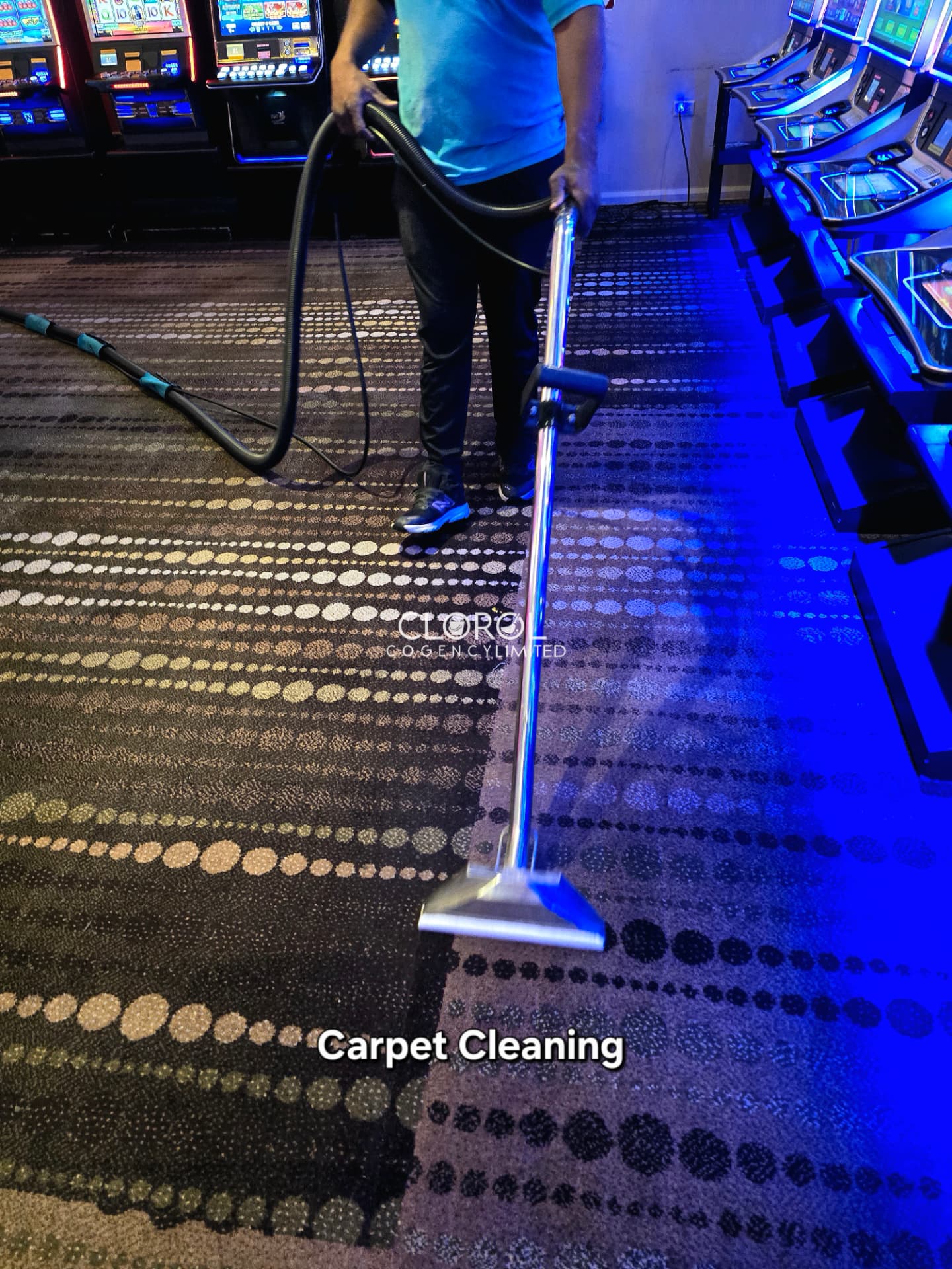 Clorol Cogency crew member deep cleaning patterned carpet on a casino gaming floor between slot machines